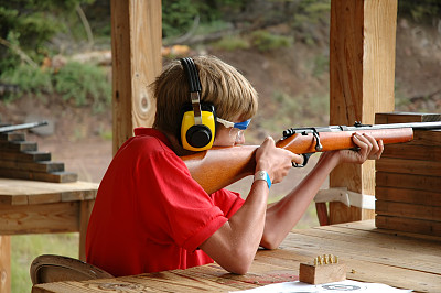 一名年轻的童子军在步枪靶场射击步枪图片下载