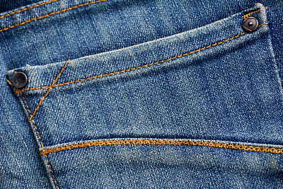牛仔牛仔裤，有邮票和洞，背景图片下载