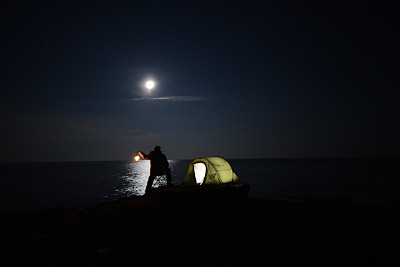 一个帐篷在满是星星的夜空下闪闪发光。图片下载