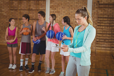 教练在篮球场的写字板上写字图片下载