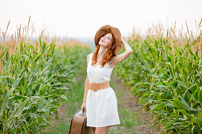 美丽的年轻女子与手提箱的照片在美妙的野外背景图片下载