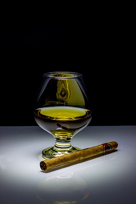 白兰地和雪茄在黑色的背景上图片下载