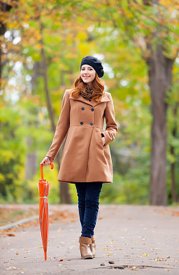 美丽的年轻女人的照片与伞在美妙的秋天公园的背景图片下载