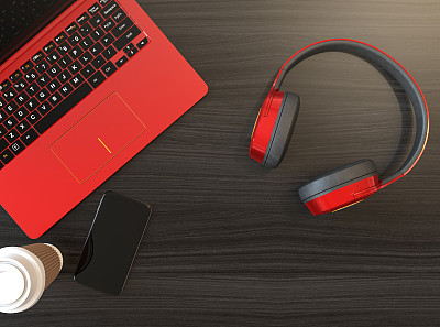 黑色木桌上放着无线耳机和金属红色笔记本电脑图片下载