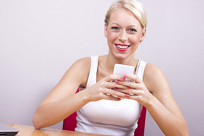 年轻的金发女人拿着智能手机图片下载