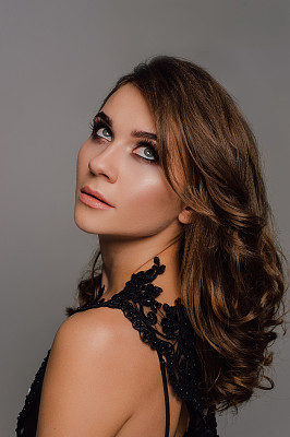 关闭了。的个性。体贴优雅的女士在黑色舞会晚礼服。工作室处理过的照片。图片下载