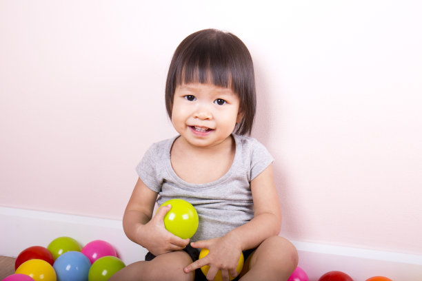 小女孩在球坑里玩彩球图片下载