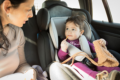 母亲和婴儿在汽车座椅上图片下载