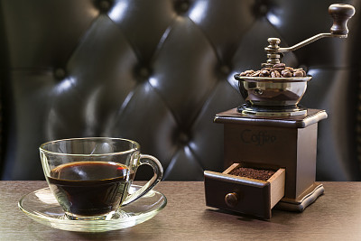 木桌上放着旧咖啡研磨机和咖啡杯图片下载