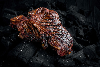 在炭火上烤着美味的腌t骨牛排。关闭视图图片下载