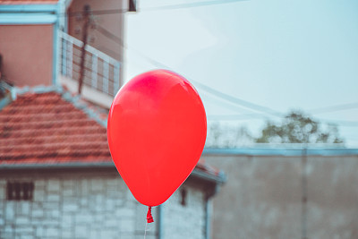 一个红色气球在阳光明媚的户外。图片下载