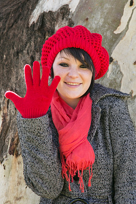 年轻女子举起戴着手套的手图片下载