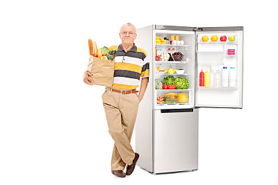 一个拿着袋子的人在一个敞着的冰箱旁图片下载