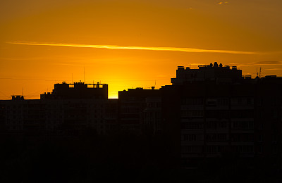 城市上空黄色的夕阳，建筑物的黑色剪影图片下载