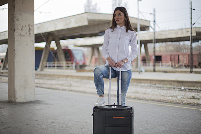 年轻漂亮的女人在火车站等候图片下载