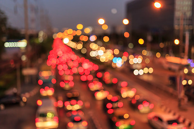 模糊照片的汽车在道路上与散景背景的城市街道夜晚灯光。图片下载