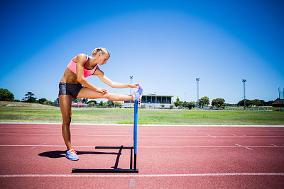 女运动员在跑道上热身图片下载