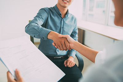 微笑的亚洲商人与合作伙伴握手素材图片