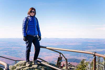 在一个阳光明媚的日子里，一个女人在山顶上微笑图片下载