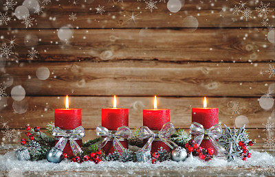 用四根燃烧的蜡烛装饰降临节。素材图片