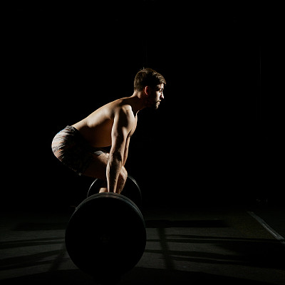 健身训练。男人用杠铃训练图片下载