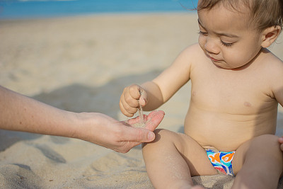 孩子和妈妈在沙滩上玩沙子图片下载