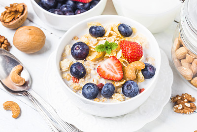 脆片配蓝莓和各种酸奶作为健康早餐，特写图片下载