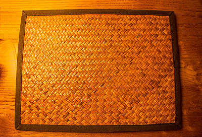 木桌背景上的空竹编织席图片下载