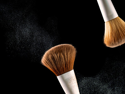 化妆刷上黑色背景闪爆喷溅粉阴影腮红。图片下载