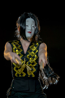 拿着鼓槌的鼓手，在黑暗的背景下拍摄。图片下载