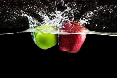 绿色和红色的苹果果实落入水中图片下载