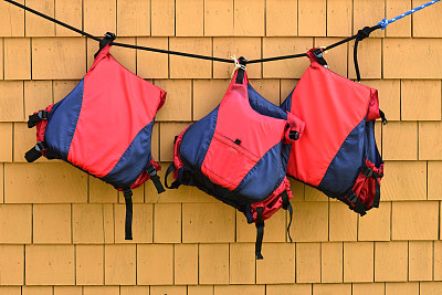 三件救生衣挂在墙上图片下载