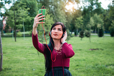 女人在公园享受自由时间和自拍。图片下载