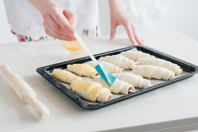 年轻漂亮的女人在准备自制的羊角面包图片下载