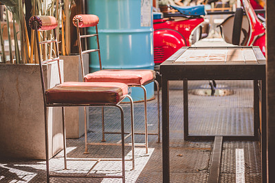 阳光下的旧钢椅和钢桌。图片下载