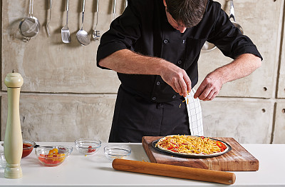 餐厅酒店私人厨师准备披萨添加配料图片下载