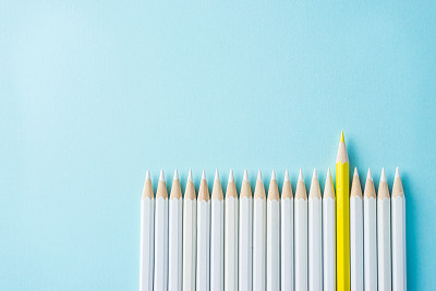 许多白色铅笔和一个彩色铅笔在蓝色纸的背景图片下载