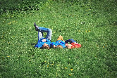 父亲带着儿子和女儿在绿色的草地上休息图片下载