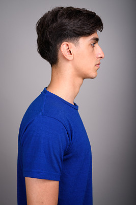 灰色背景前的年轻波斯少年（影棚拍摄）图片下载