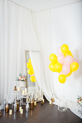 白色的墙上挂着五颜六色的气球和花图片下载