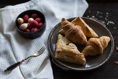 从自然光中拍摄烘焙照片。盘子放在桌子上的黑木头图片下载