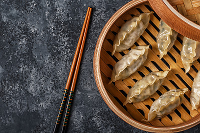 新鲜的饺子在一个黑色的石头背景。素材图片