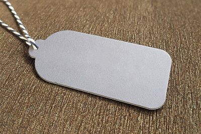 灰色的价格标签挂在棕色天鹅绒上，有一些文字，广告，促销，销售概念的拷贝空间图片下载