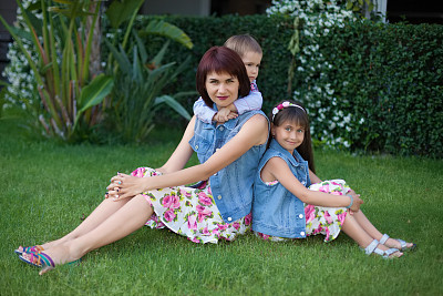 一家人坐在公园的草地上图片下载