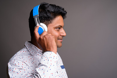 在灰色背景下拍摄的年轻印度商人图片下载