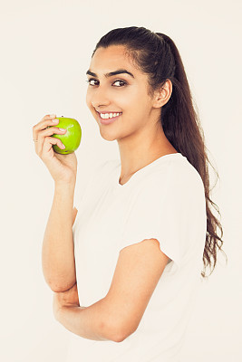 微笑的年轻漂亮的印度女人拿着苹果图片下载