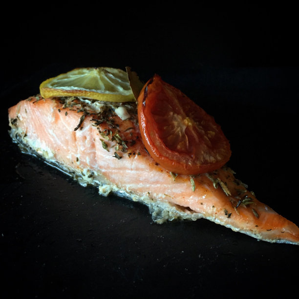 烤三文鱼里脊配柠檬角，番茄和香草。特写镜头。图片下载