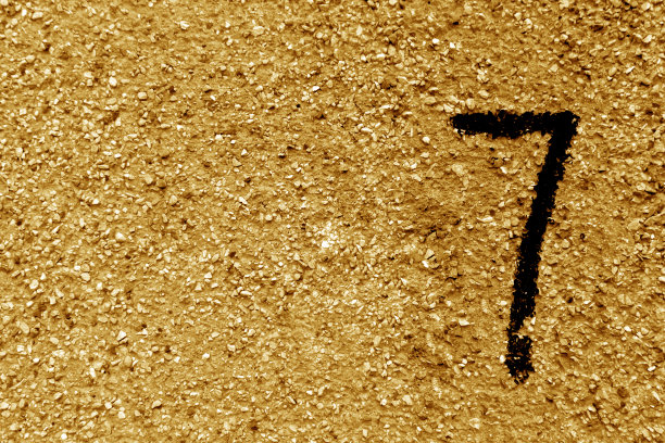 橘色脏水泥墙上的七号。图片下载