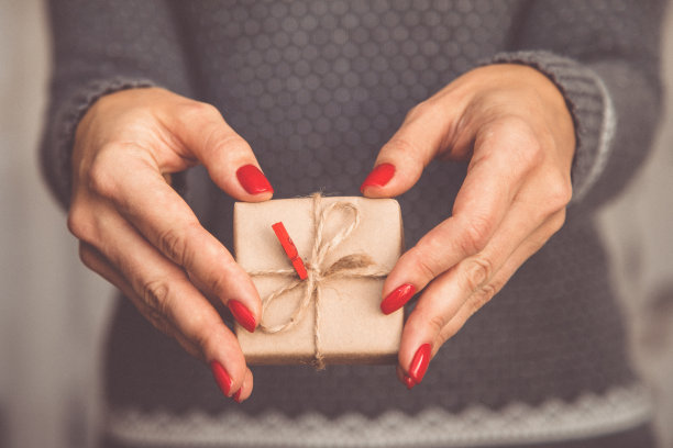 女人的手捧着圣诞或新年装饰的礼品盒。健美的图片图片下载