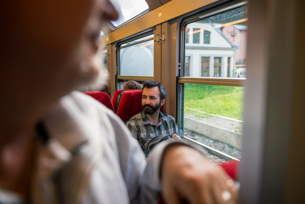 在阳光明媚的夏日里，年轻的成年人坐火车上下班图片下载